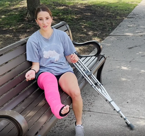 Summer School Soccer Saga - In this clip, we meet a college soccer player who emerges from her car still in her uniform but also with a half leg fiberglass splint adorning her right leg (to go with soccer sock and croc on her left).  She crutches...