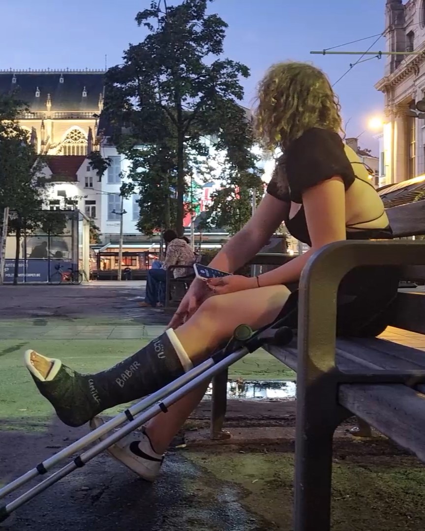We meet this beautiful girl, in real black fiber slc torplate on the street. She is sitting on the bench. Then she starts walking around town on his crutches.