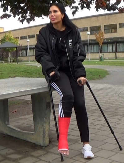 Flower SLC #92 - Wearing a red SLC, white sneakers and training pants, Flower takes a walk with her crutches in to a schoolyard in this clip. Flower sits down for a while to rest and meanwhile her cast is filmed in close-up.