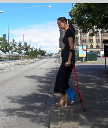 Sunshine LLC #64 - We meet Sunshine on a nice summer day in her hometown. She crutch across the street and down towards the canal where pedal boats float around. It's a really nice day for a walk. Sunshine crutches forward with a high-heeled shoe...