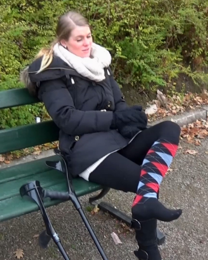 Ice Sock Sprain #1612-5 - After a rest on a bench, Ice take her crutches and start crutching in to the park with her hurt foot in a long black, red and blue sock. She take her crutches and start crutching in to the park. We follow her as she jumps...