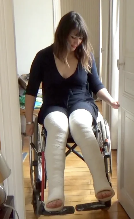 Mélanie both legs in LLC's - Mélanie is trying to deal with her two broken legs and wheelchair. She rolls around the flat, tries to play guitar and struggles with the wheels. Then she transfers herself to the couch. These two full leg casts make...